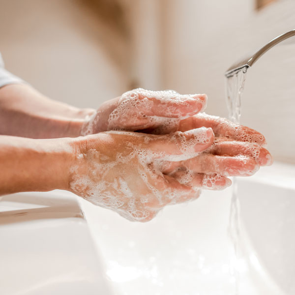 Hände unter fließendem Wasser mit Seife waschen, Nahaufnahme.